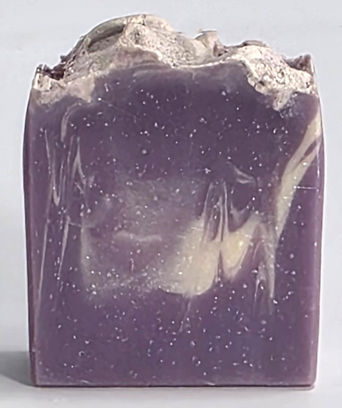 Textured top and purple and cream marbled design of a handcrafted Lavender Sky cold process soap bar.