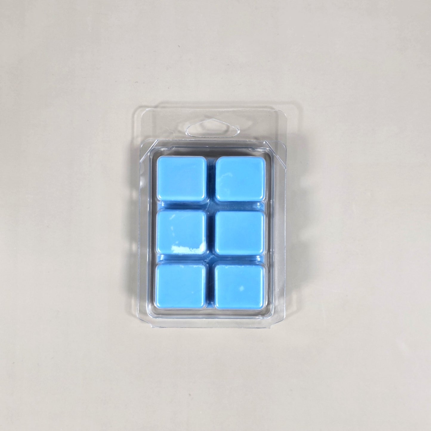 Clear 6-cavity clamshell packaging showcasing vibrant pink, hand-poured soy wax melt cubes.