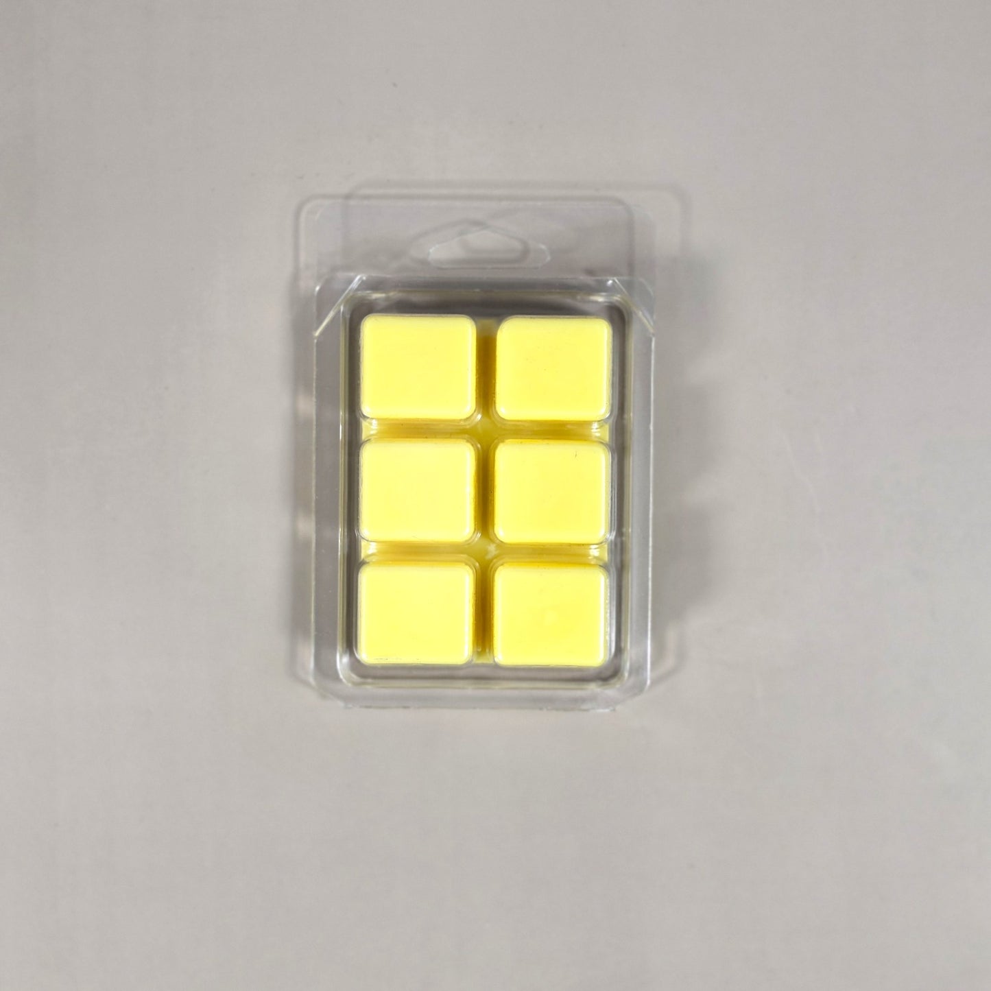 Clear 6-cavity clamshell packaging showcasing cream-colored, hand-poured soy wax melt cubes for home fragrance.