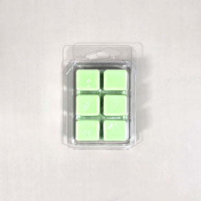 Clear 6-cavity clamshell packaging featuring vibrant light green soy wax melt cubes for home fragrance.