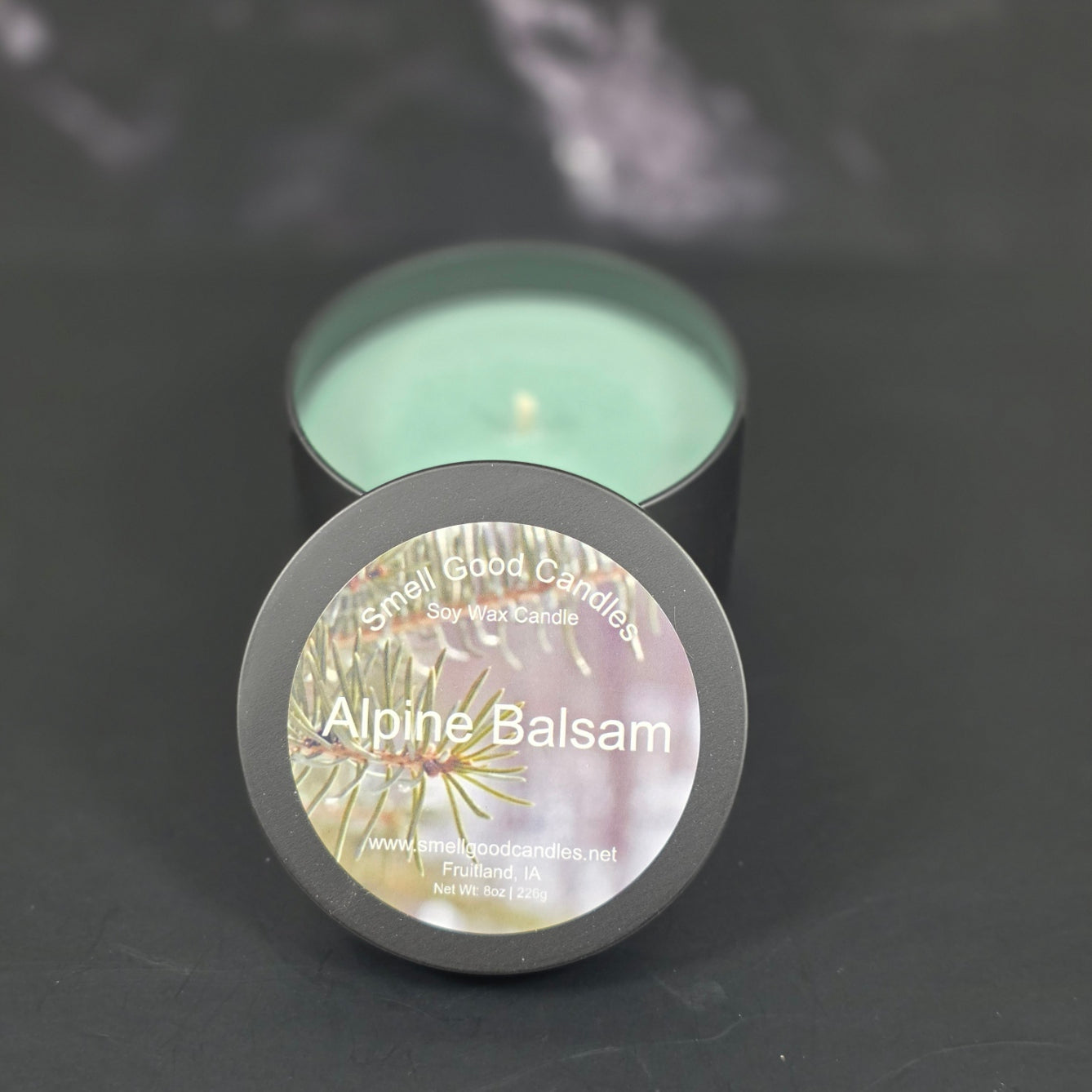 Hand-poured Alpine Balsam soy wax candle by Smell Good Candles — a refreshing pine and balsam Christmas scent in a matte black jar with green wax.