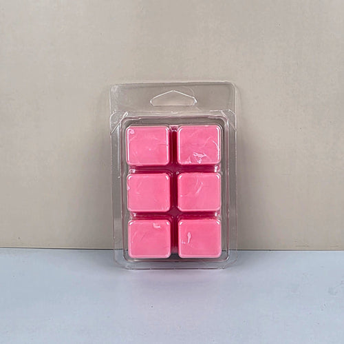 Pack of pink wax melts in clear packaging on a light gray background