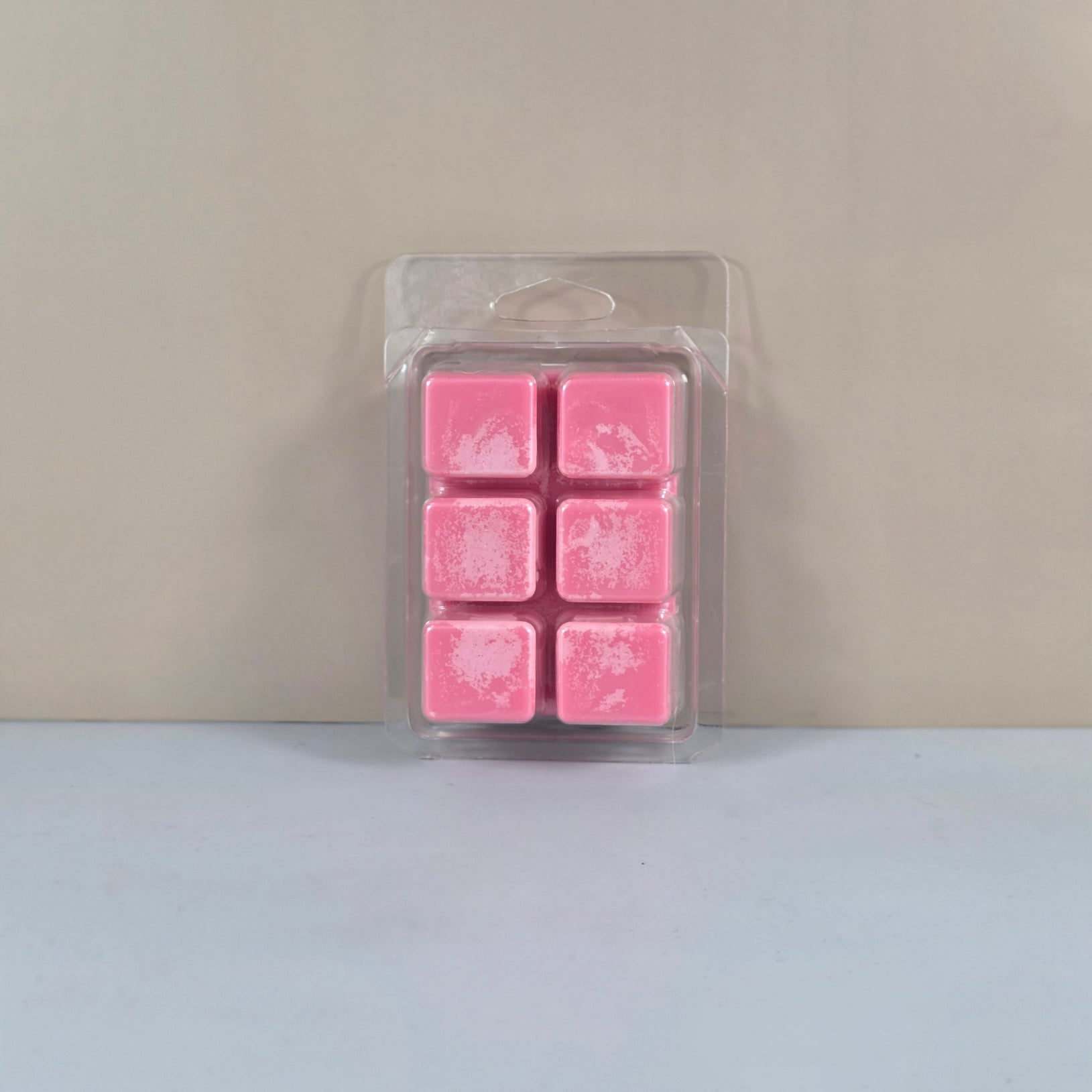 6-cavity clear plastic clamshell packaging filled with bright pink six-cube soy wax melts