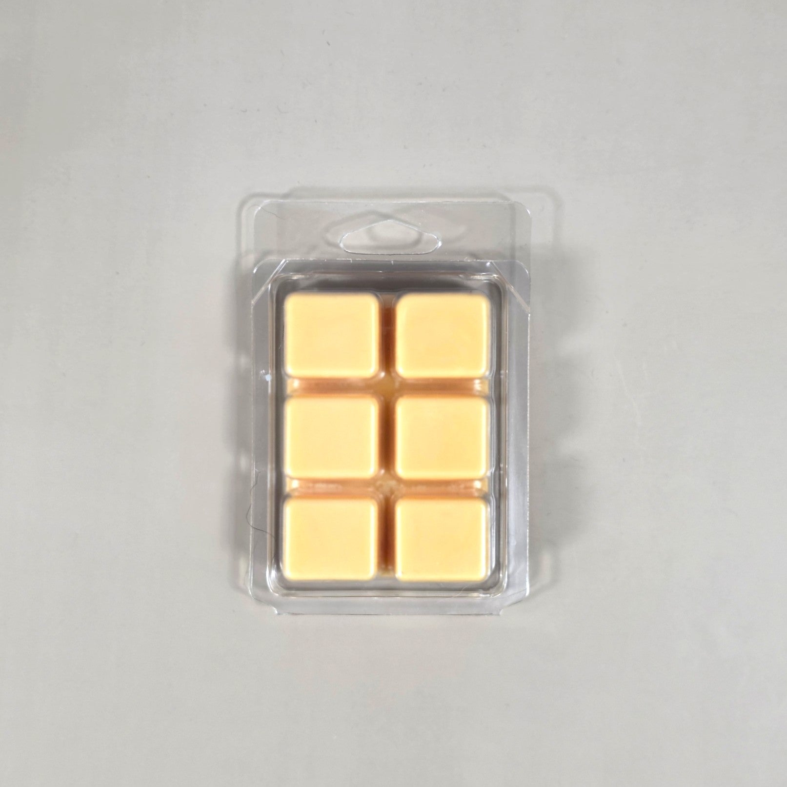 Clear 6-cavity clamshell packaging showcasing cream-colored, hand-poured soy wax melt cubes for home fragrance.