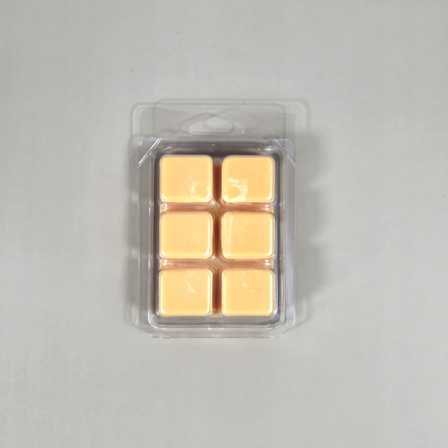 Clear 6-cube plastic clamshell packaging showcasing peach-colored soy wax melts for home fragrance.