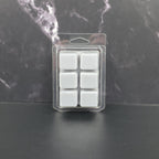 Pack of six gray wax melts in clear packaging on a dark marble background