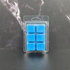 Clear plastic packaging with six blue square items on a dark marble surface