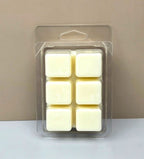Close-up of the bottom of a six-cavity wax melt clamshell showing creamy white, hand-poured wax cubes.