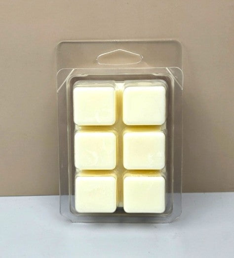 Underside view of a clear wax melt clamshell showing six uniform, hand-poured white wax cubes.