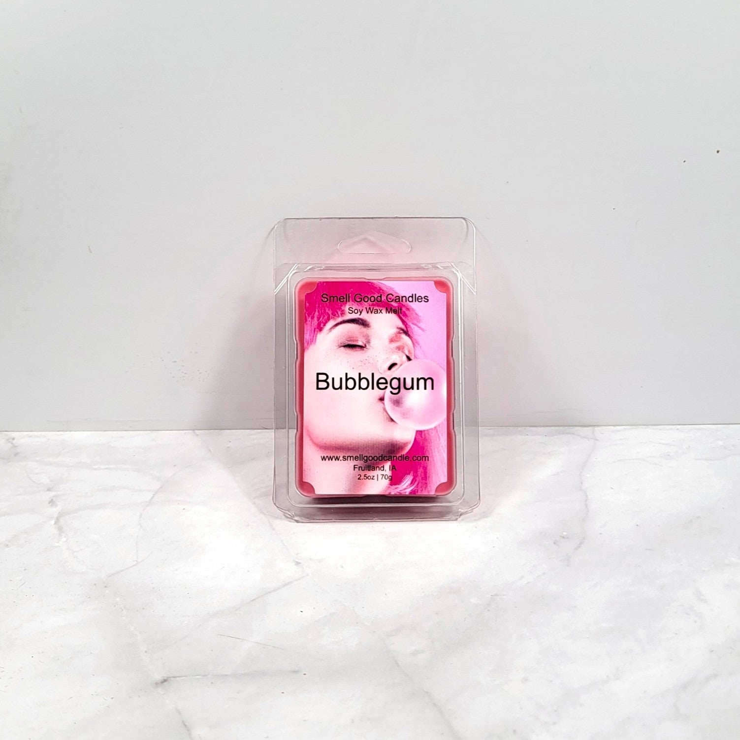 Pink bubblegum scented wax melt packaging on a white marble surface