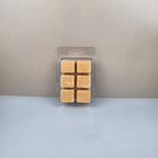 Pack of six gold-colored wax melts in a clear plastic packaging against a neutral background
