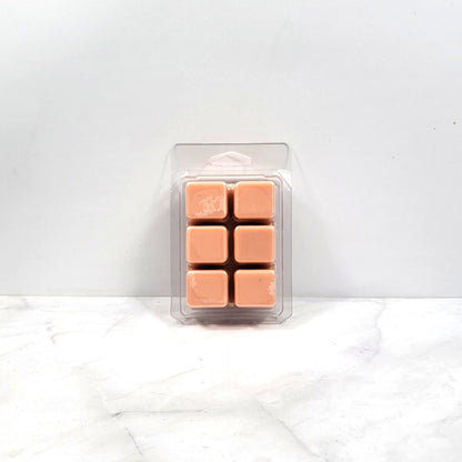 Pack of tan-colored wax melts in a clear plastic packaging on a white background