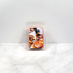 Candle wax melt package labeled 'Cinnamon Caramel' on a white surface.