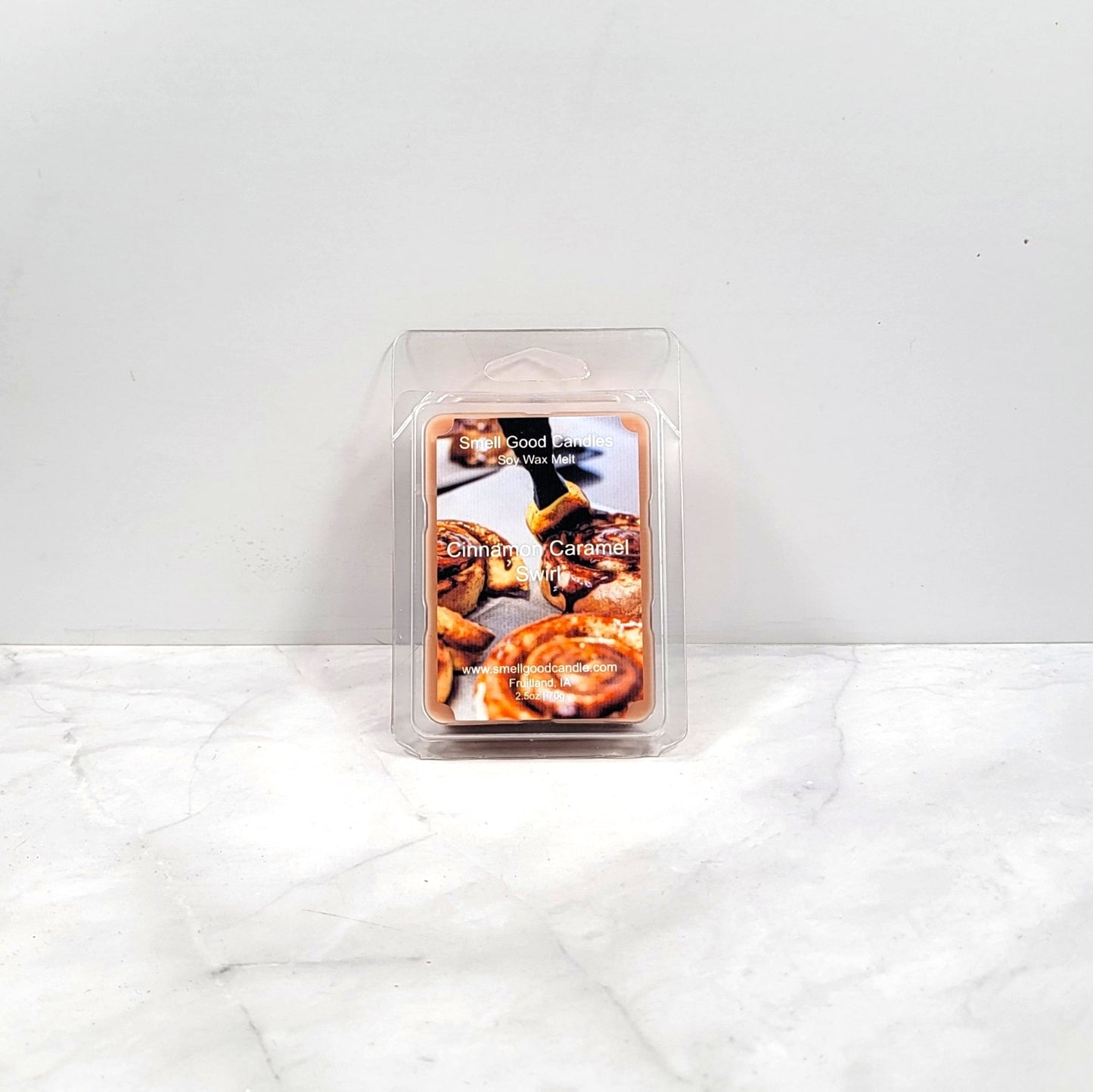 Candle wax melt package labeled 'Cinnamon Caramel' on a white surface.