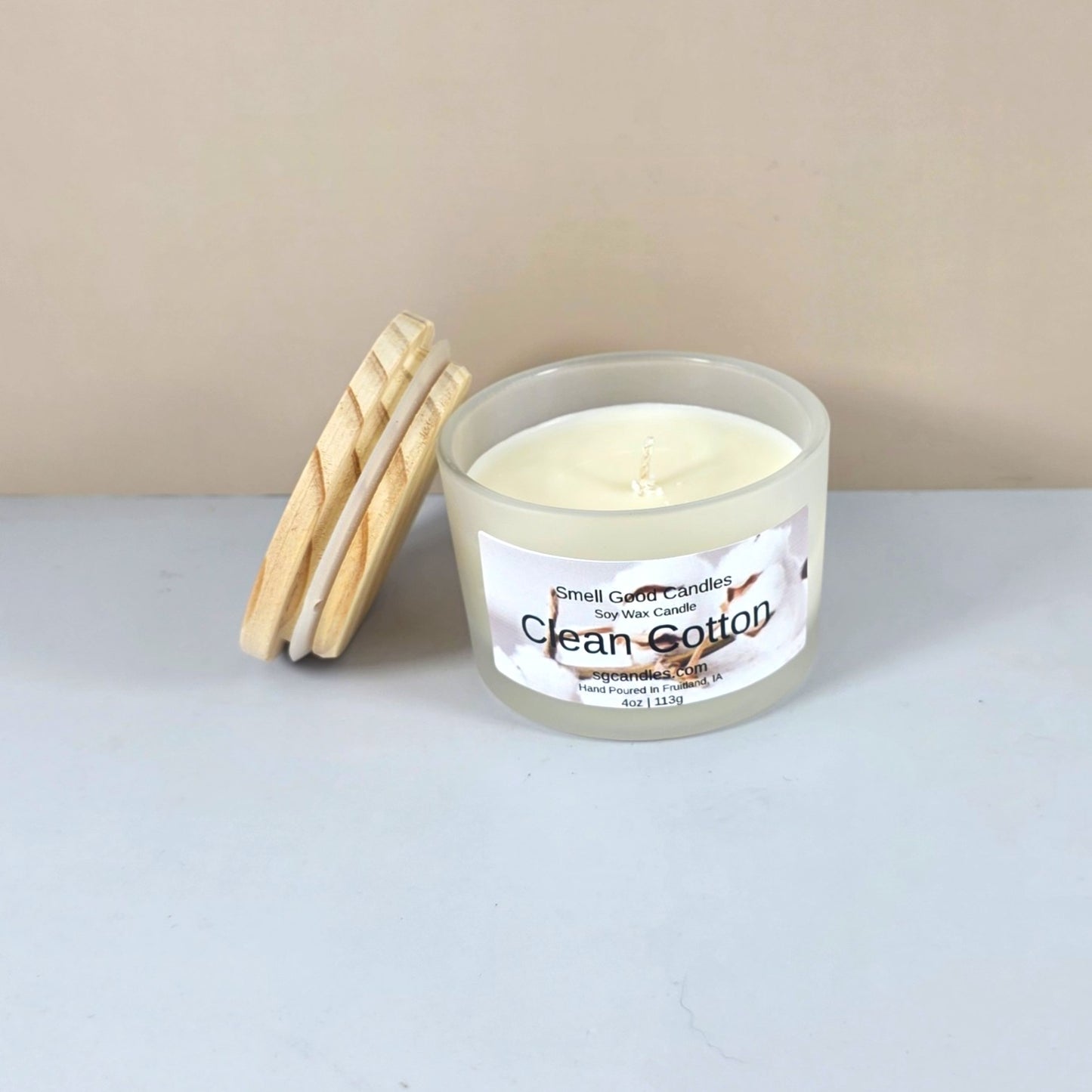 Artisanal clean cotton scented candle with wood lid, styled on a marble surface.