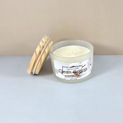 Artisanal clean cotton scented candle with wood lid, styled on a marble surface.