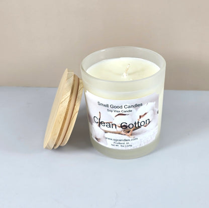 Artisanal clean cotton scented candle with wood lid, styled on a marble surface.