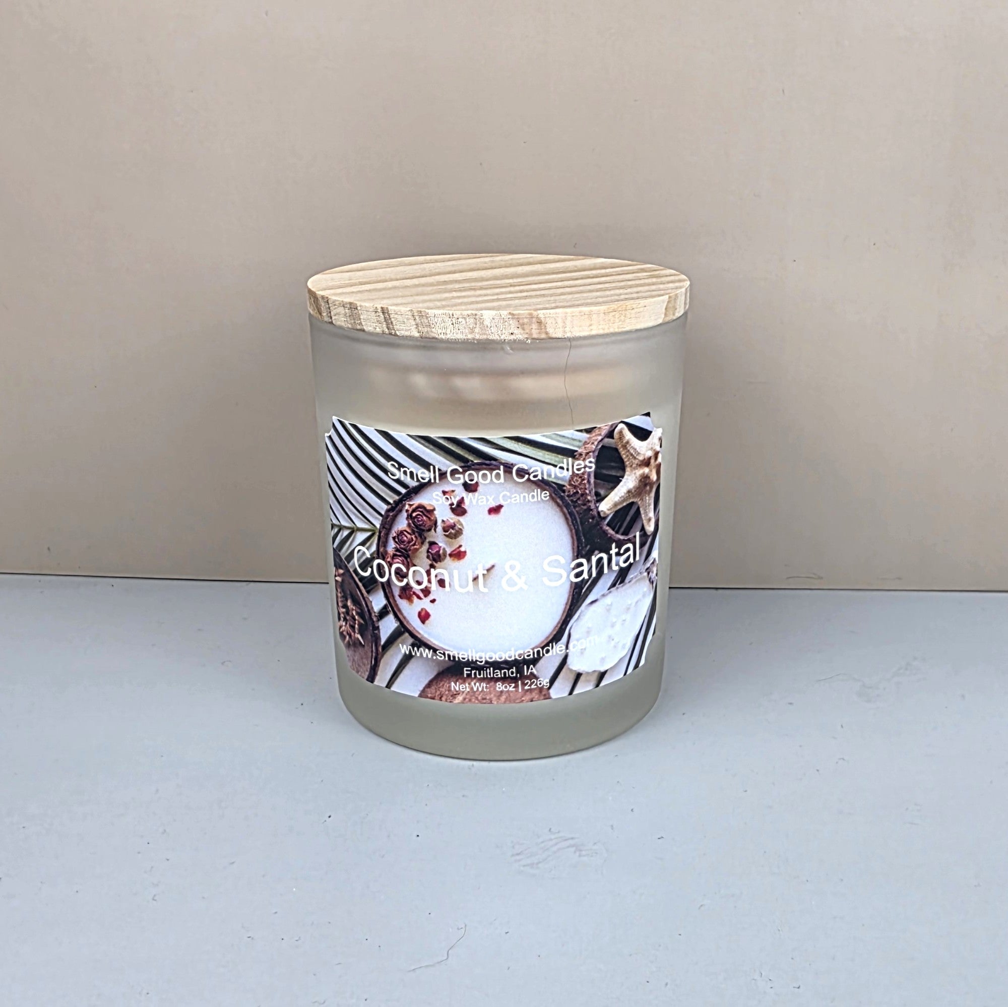 Coconut and santal soy wax candle in a white frosted jar with wood lid