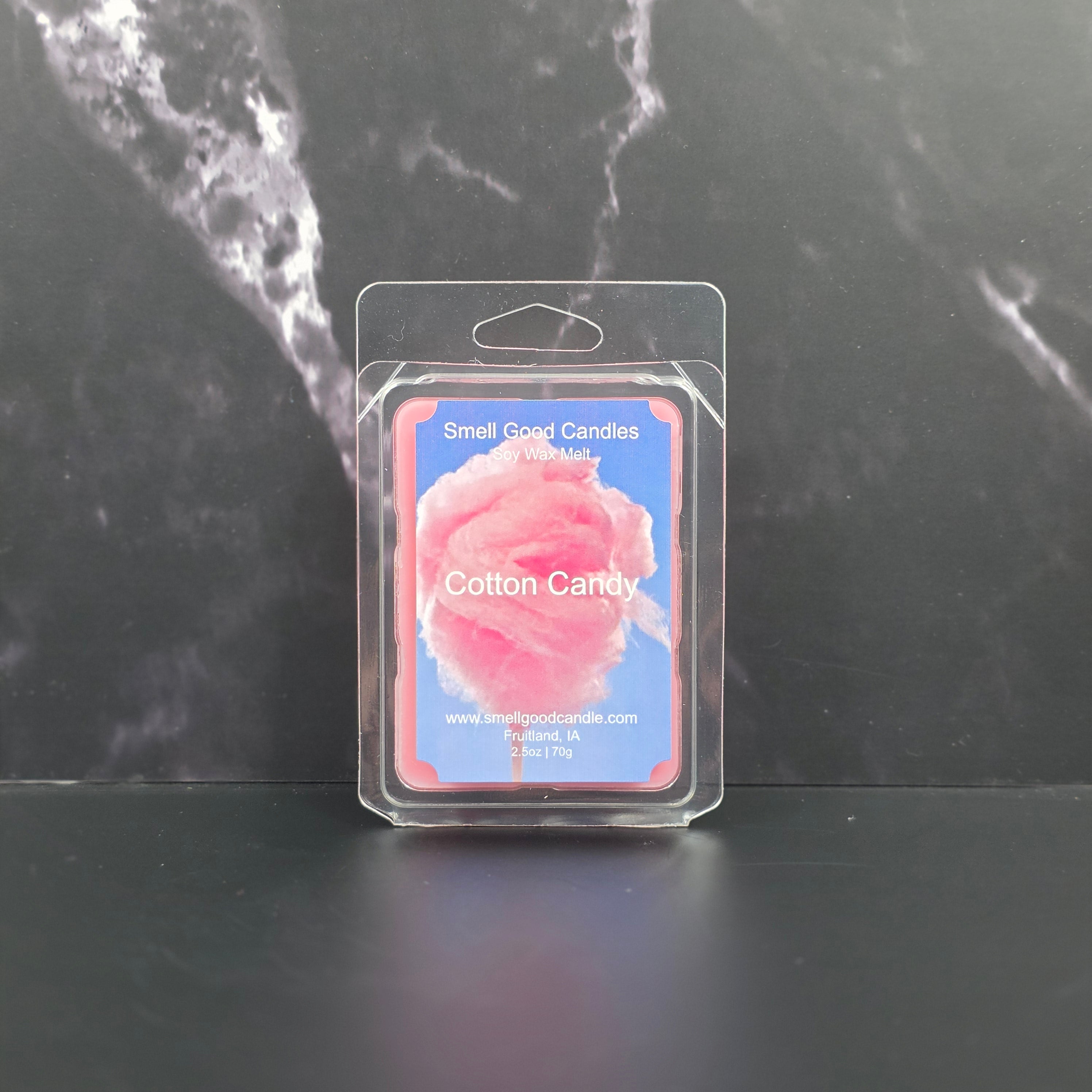 Cotton candy wax melt package on a dark marble surface