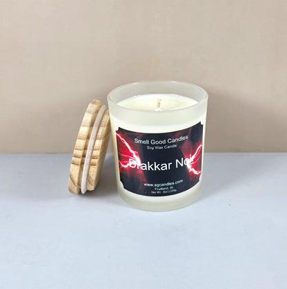 Close-up of Drakkar Noir artisan candle with wood lid on a dark table.