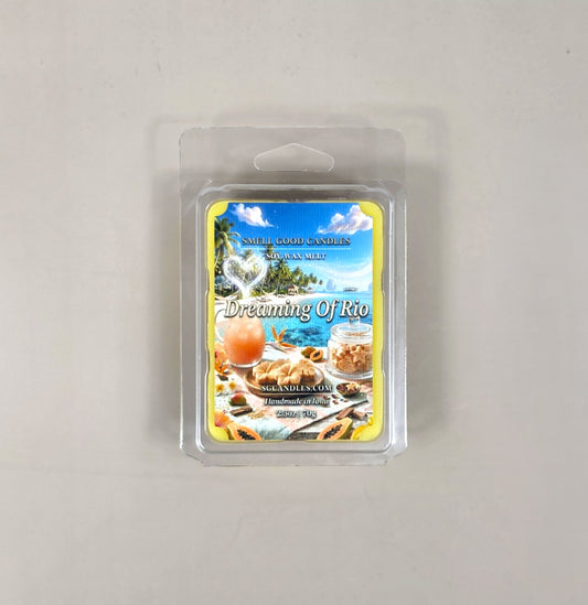 Top view of Dreaming of Rio fragrance soy wax melt in a 2.5oz clear clamshell package featuring a tropical beach vacation label with a beachy drink and sliced papaya fruit.