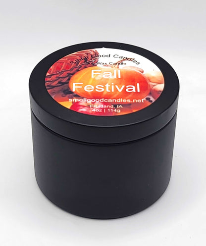 Cozy fall candle in reusable tin surrounded by leaves and pumpkins