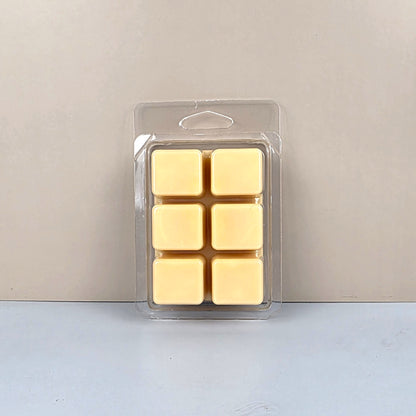 Pack of six yellow wax melts in clear packaging on a light gray background