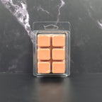 Six-pack of brown Hot Cocoa scented soy wax melts displayed on a black marble background.