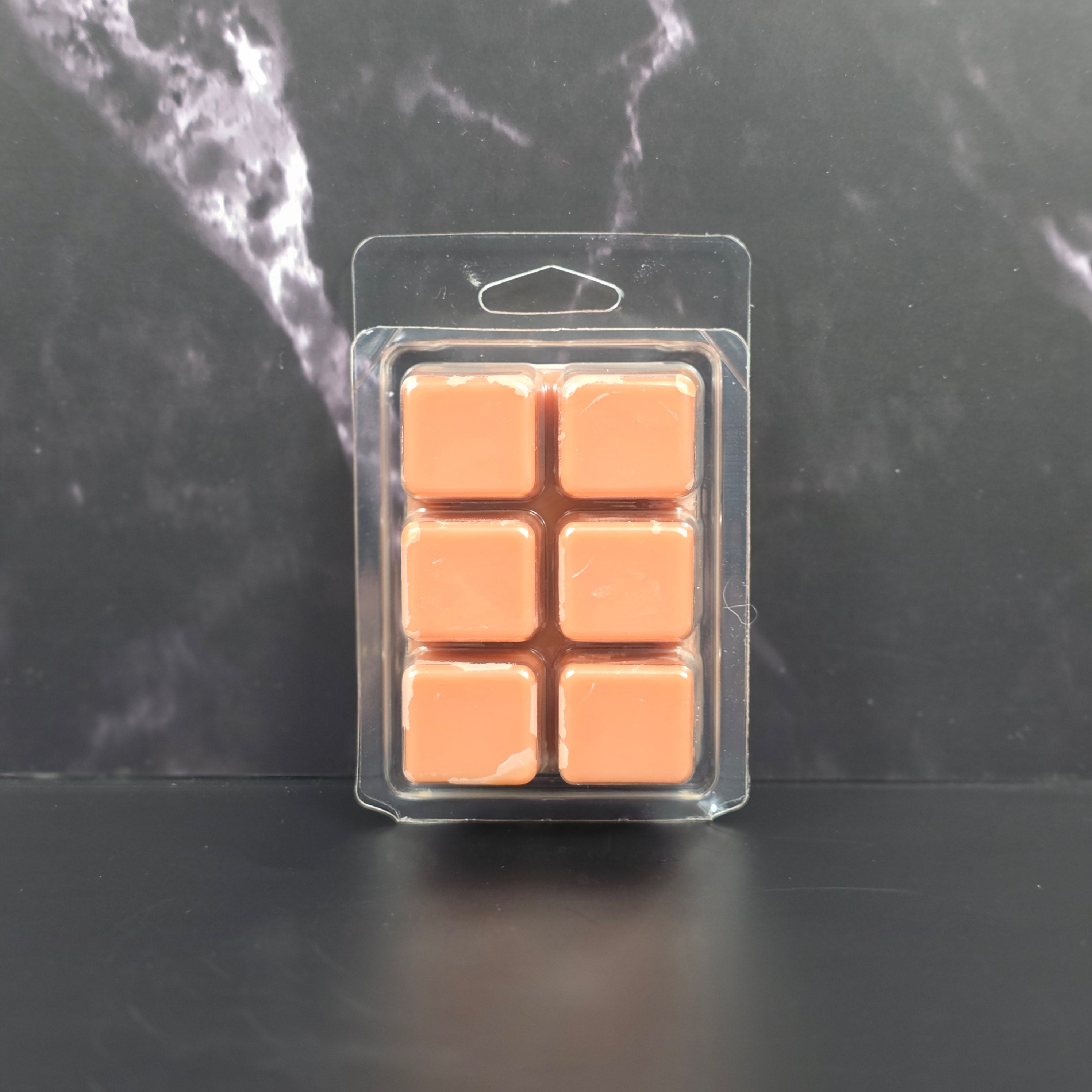 Six-pack of brown Hot Cocoa scented soy wax melts displayed on a black marble background.