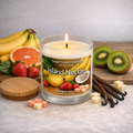 Island Nectar banana scented soy wax candle in a white frosted glass jar with wooden lid, lit single wick, styled with bananas, grapefruit, kiwi, strawberries, and vanilla.