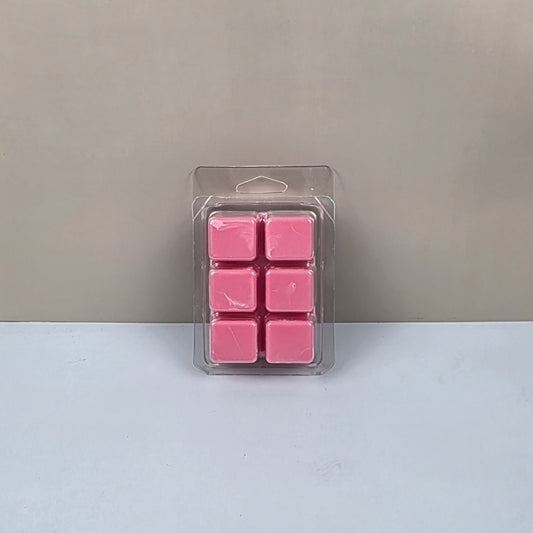Pack of pink wax melts in clear packaging on a light gray background