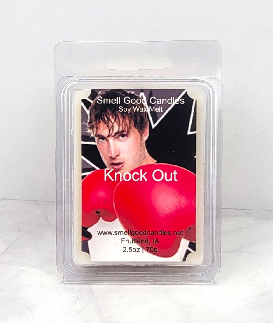 A soy wax melt in packaging, with a label featuring a male model and the scent name 'Knock Out'. The background is white, and the wax melt is visible through the clear plastic front of the package.