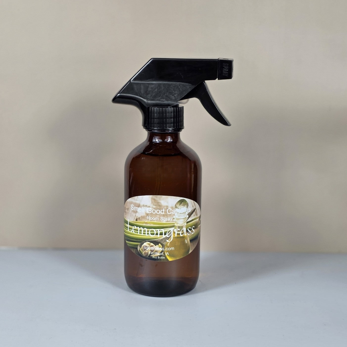 Hand-poured lemongrass home fragrance spray styled with fresh green herbs and citrus accents.