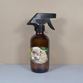 Brown spray bottle with a monkey on the label eating a banana on a beige background