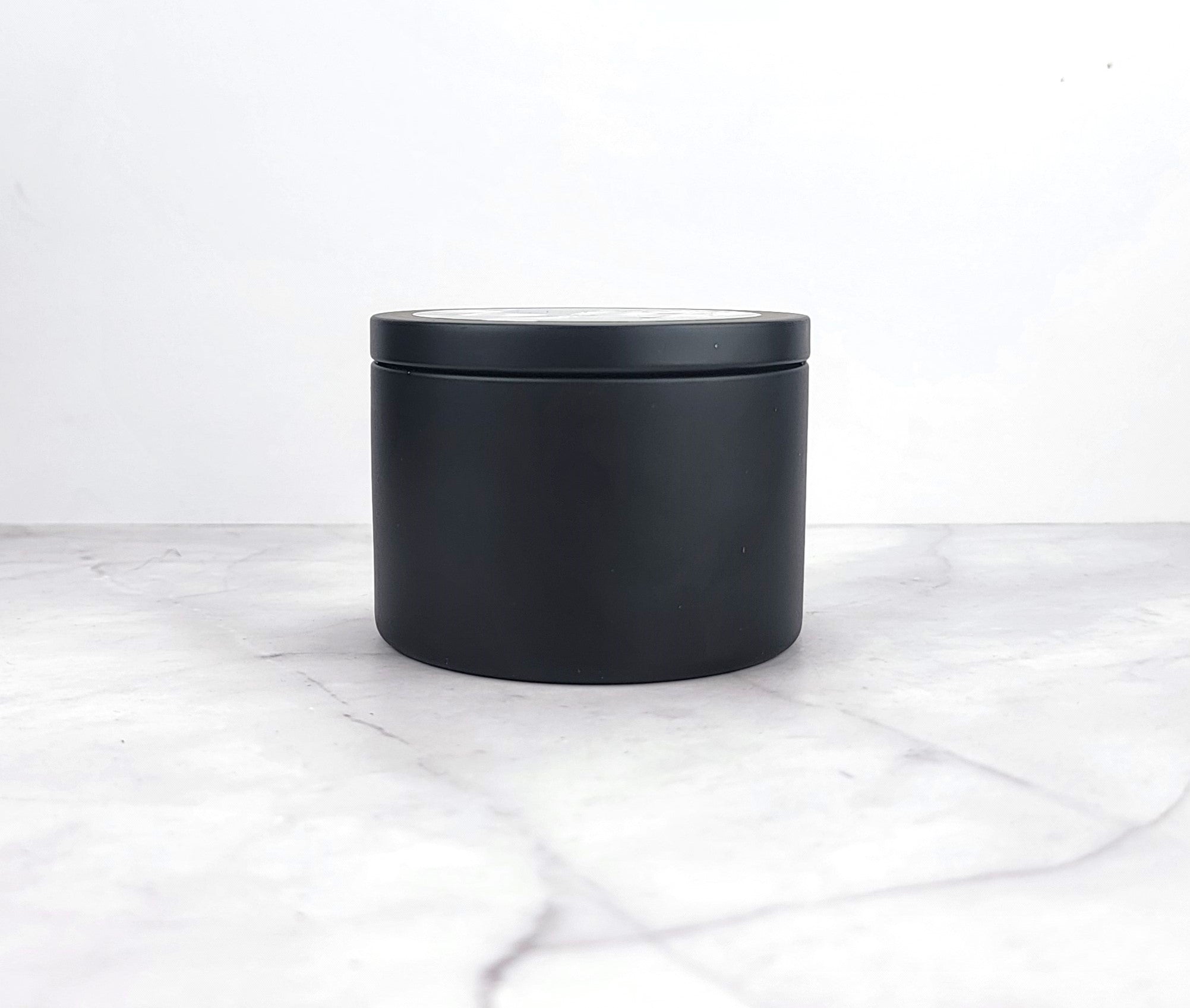 Close-up of soy wax candle with floral fragrance elements.