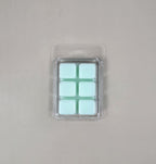 Pack of light blue wax melts in clear packaging on a gray background