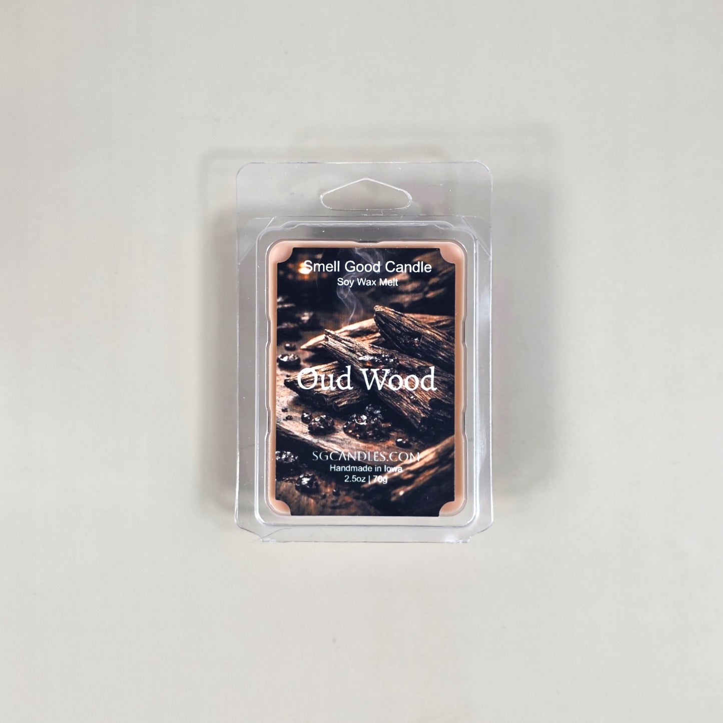 Labeled Oud Wood soy wax melt in a 2.5oz clamshell with a sleek, minimalist label featuring a luxury wood texture design.