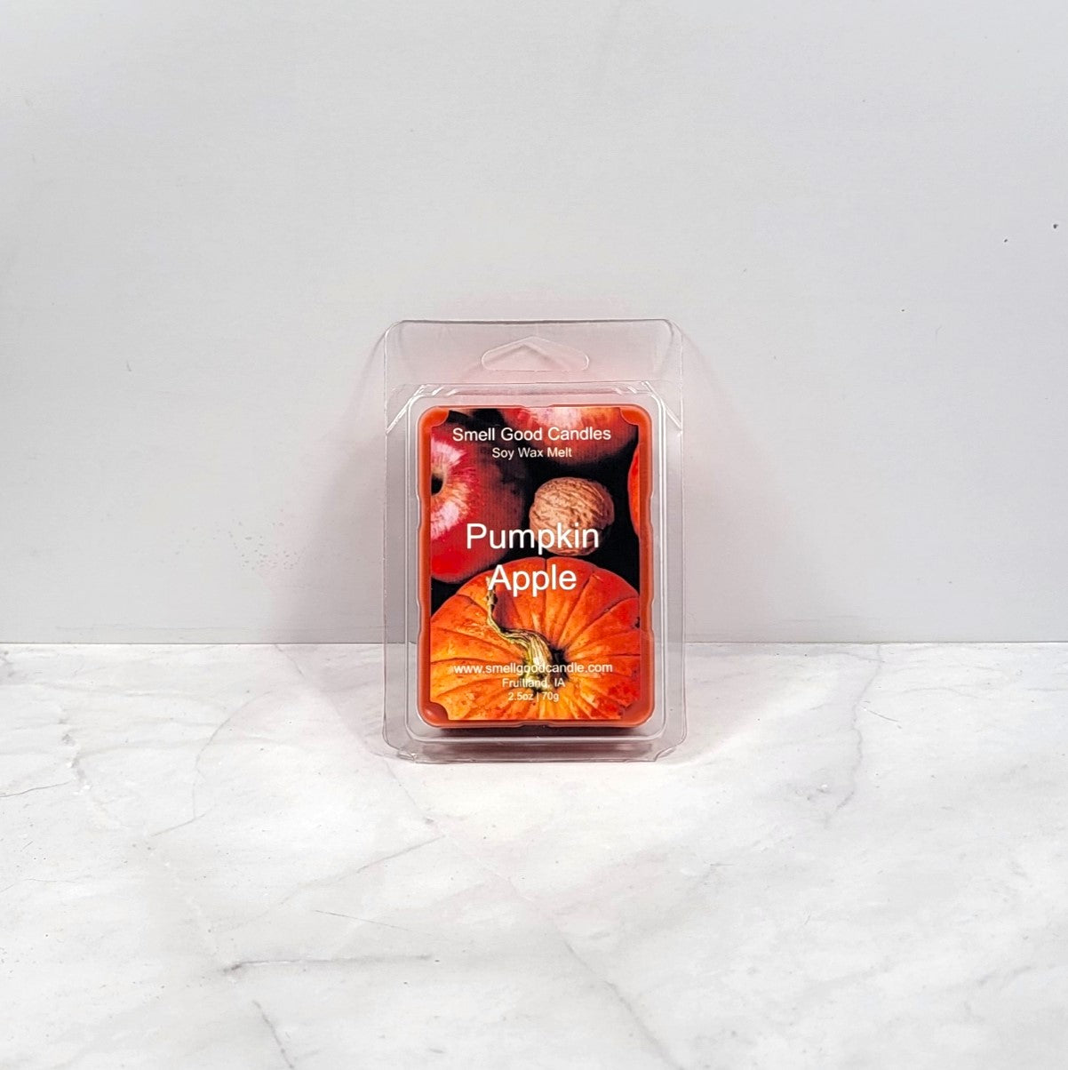 Pumpkin Apple scented candle in packaging on a white marble surface