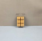 Pack of eight square wax melts in clear packaging on a beige background