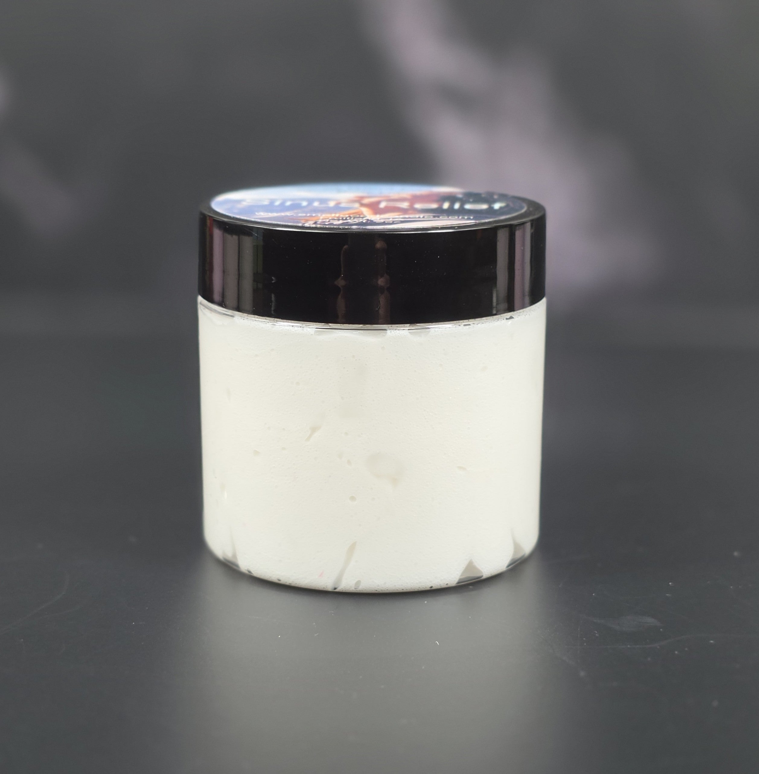 White container with black lid on a dark background