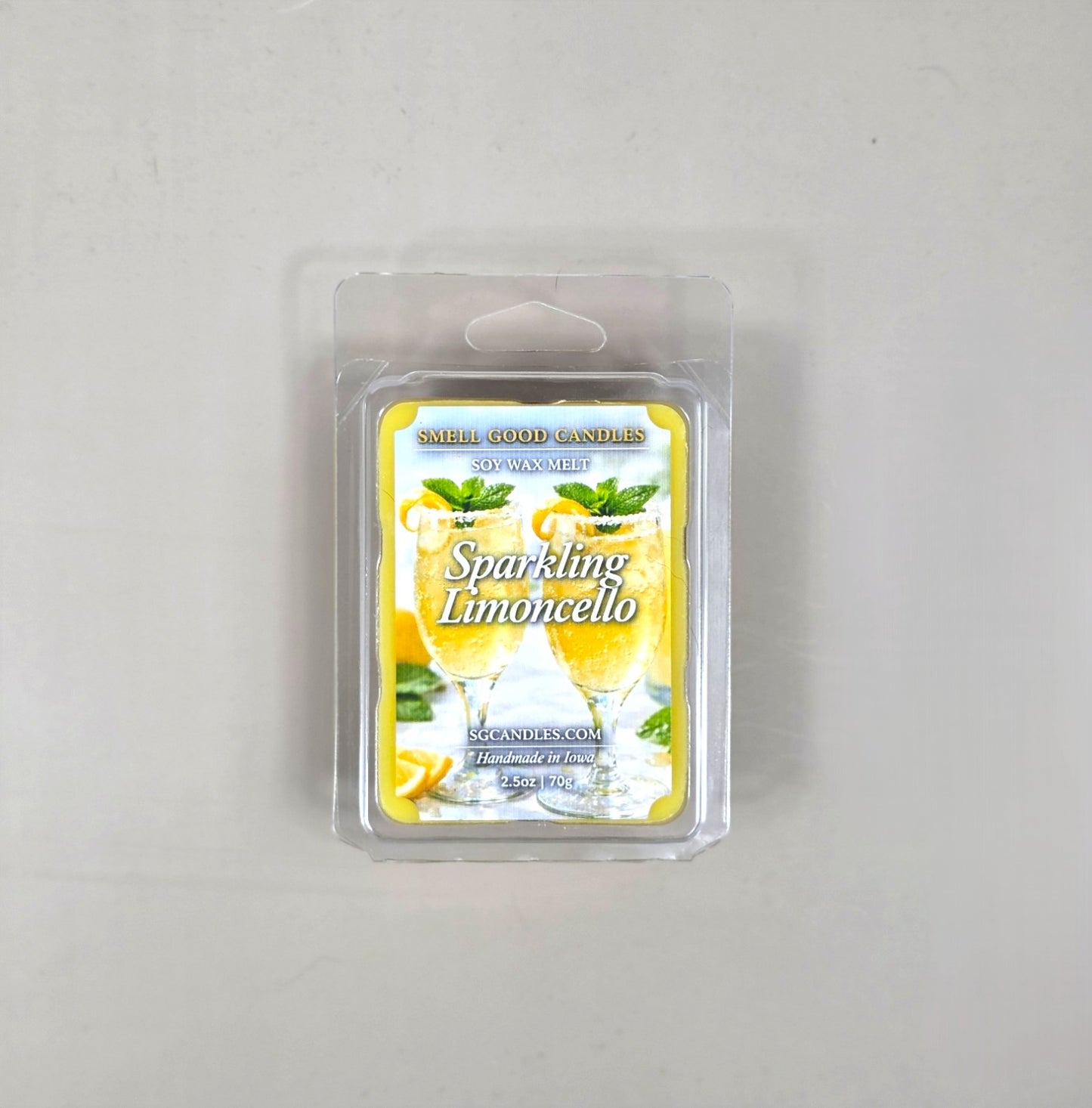 Top view of Smell Good Candles Sparkling Limoncello soy wax melt in a 2.5oz clear clamshell package featuring a vibrant label with two refreshing lemon cocktails.