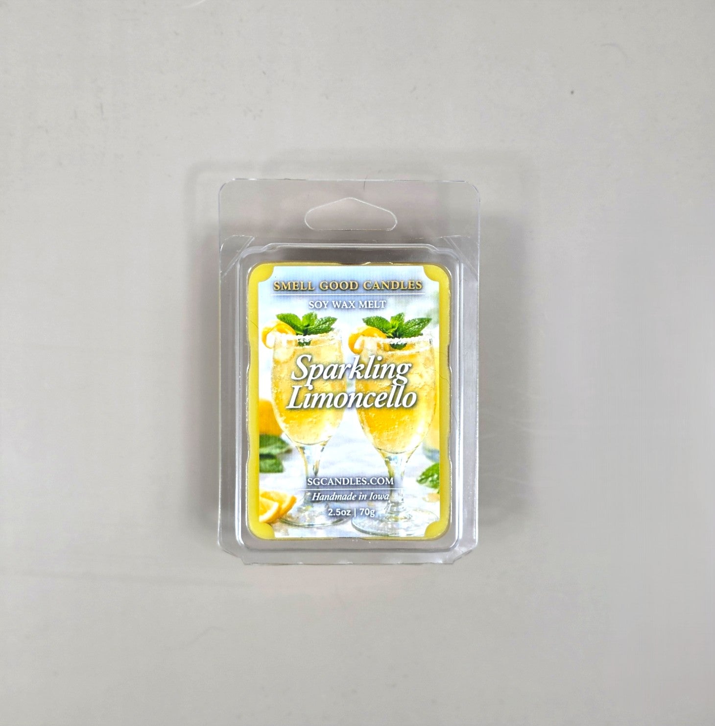 Top view of Smell Good Candles Sparkling Limoncello soy wax melt in a 2.5oz clear clamshell package featuring a vibrant label with two refreshing lemon cocktails.