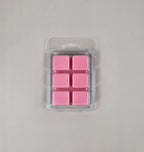 Pack of pink wax melts in a clear plastic packaging on a light gray background