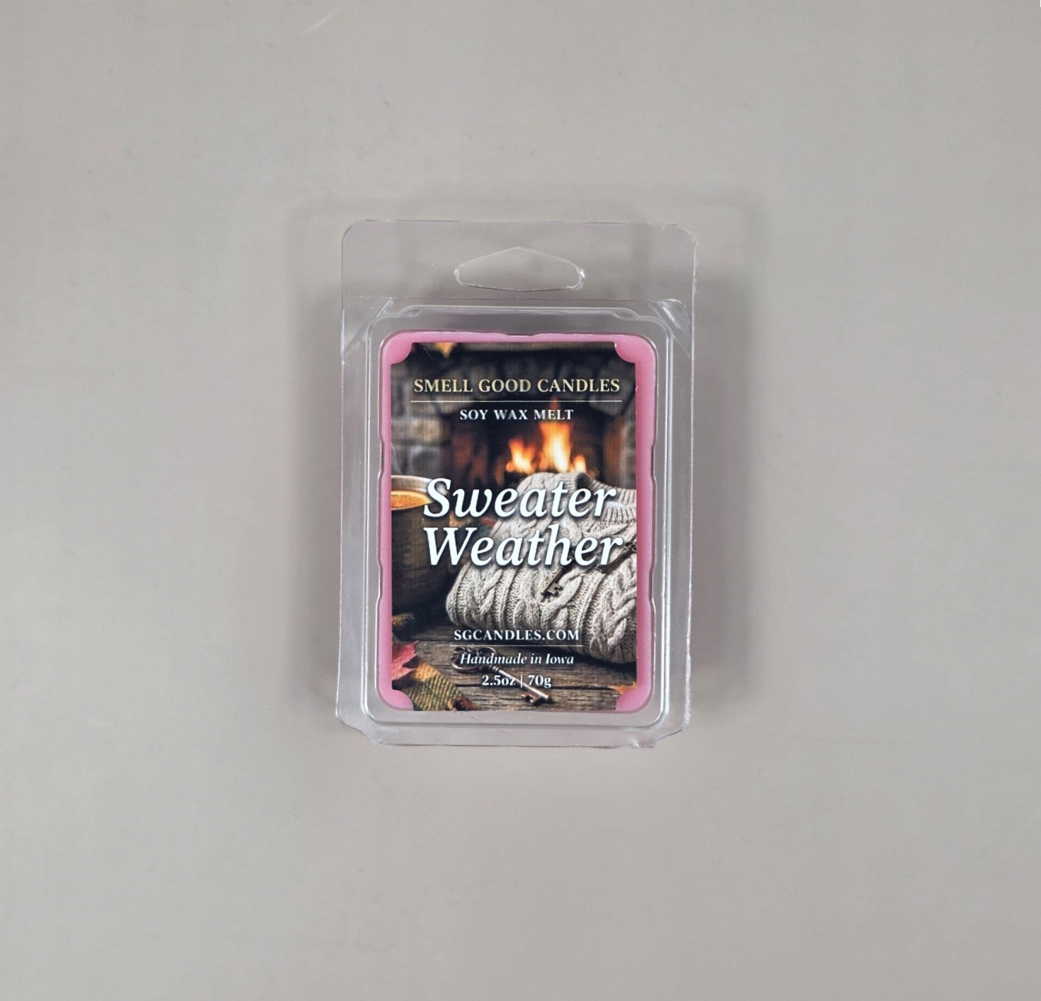 Packaged candle labeled 'Sweater Weather' on a gray background