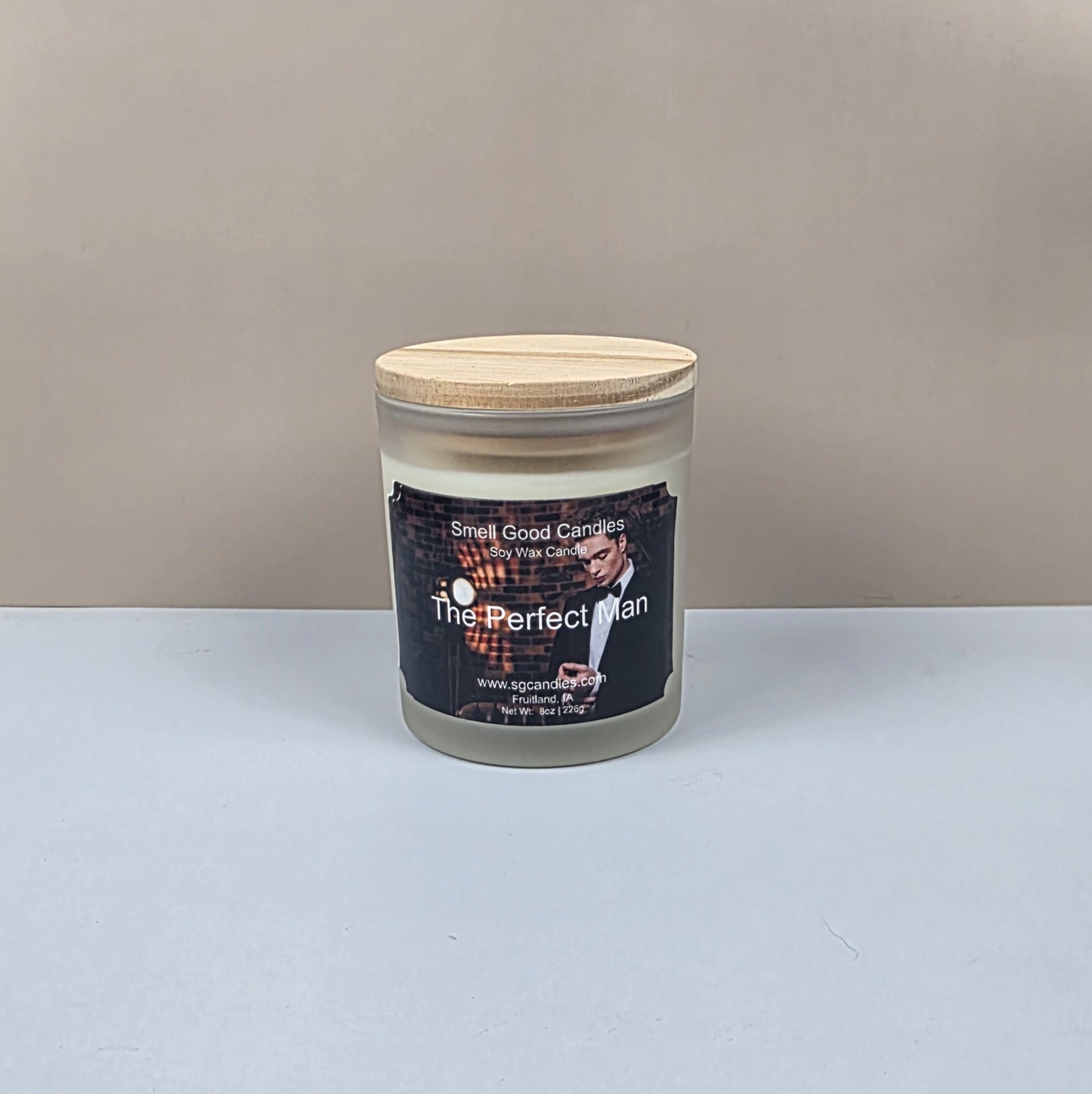 Candle in a glass jar with a wooden lid on a neutral background