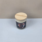 Candle jar with wooden lid on a white surface