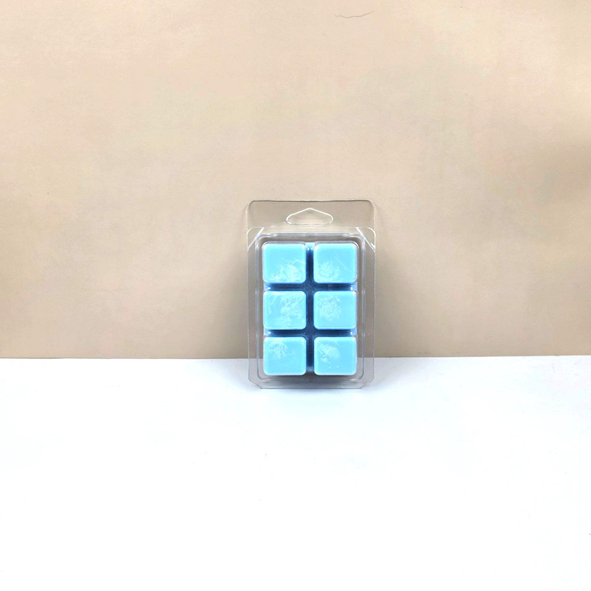 Packaged blue wax melts on a beige background