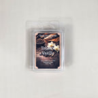 Labeled Tobacco Vanilla soy wax melt in a 2.5oz clamshell with a luxury label depicting a glass of bourbon and dried tobacco leaves.