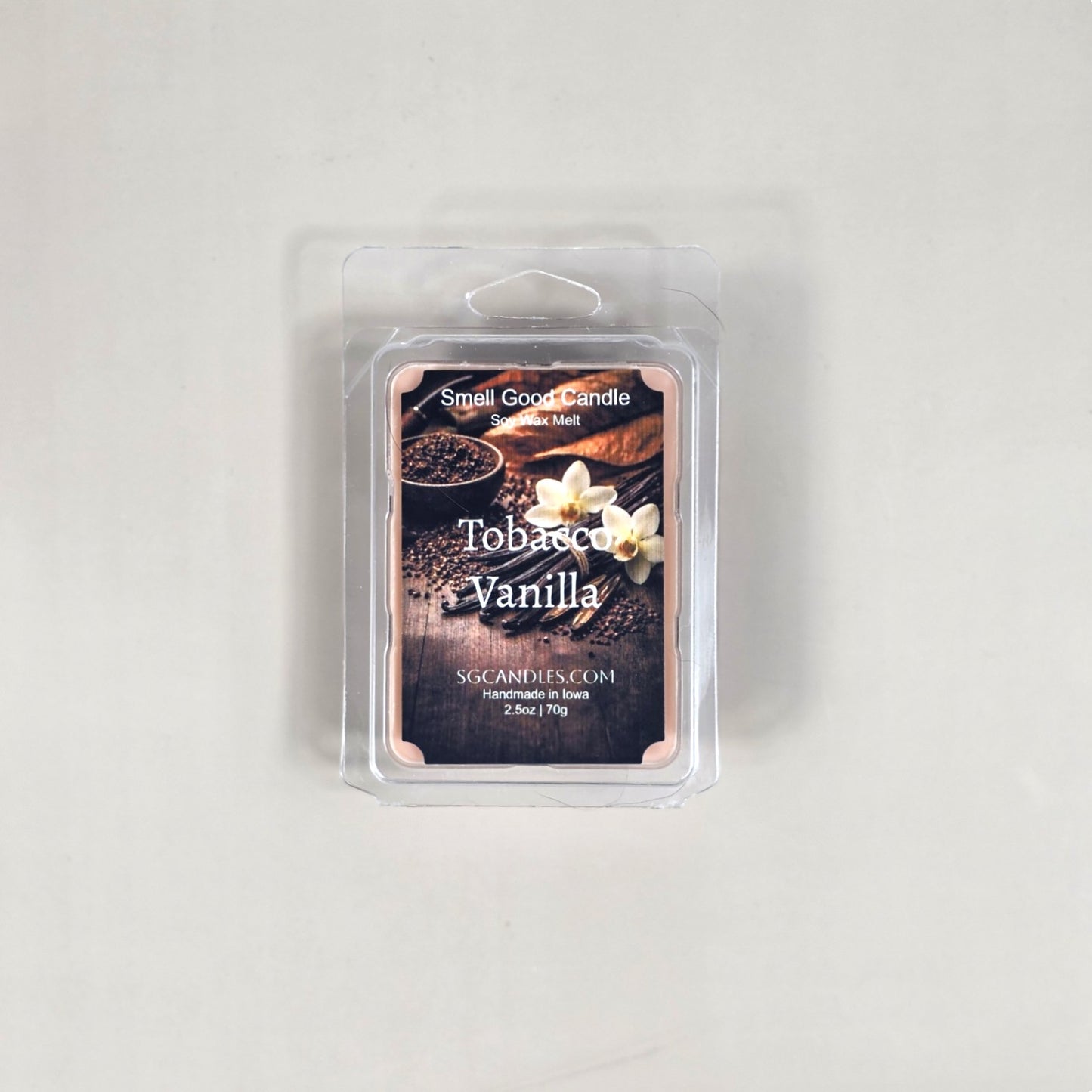Labeled Tobacco Vanilla soy wax melt in a 2.5oz clamshell with a luxury label depicting a glass of bourbon and dried tobacco leaves.