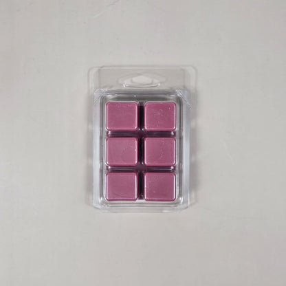 Pack of six pink wax melts in a clear plastic packaging on a light gray background